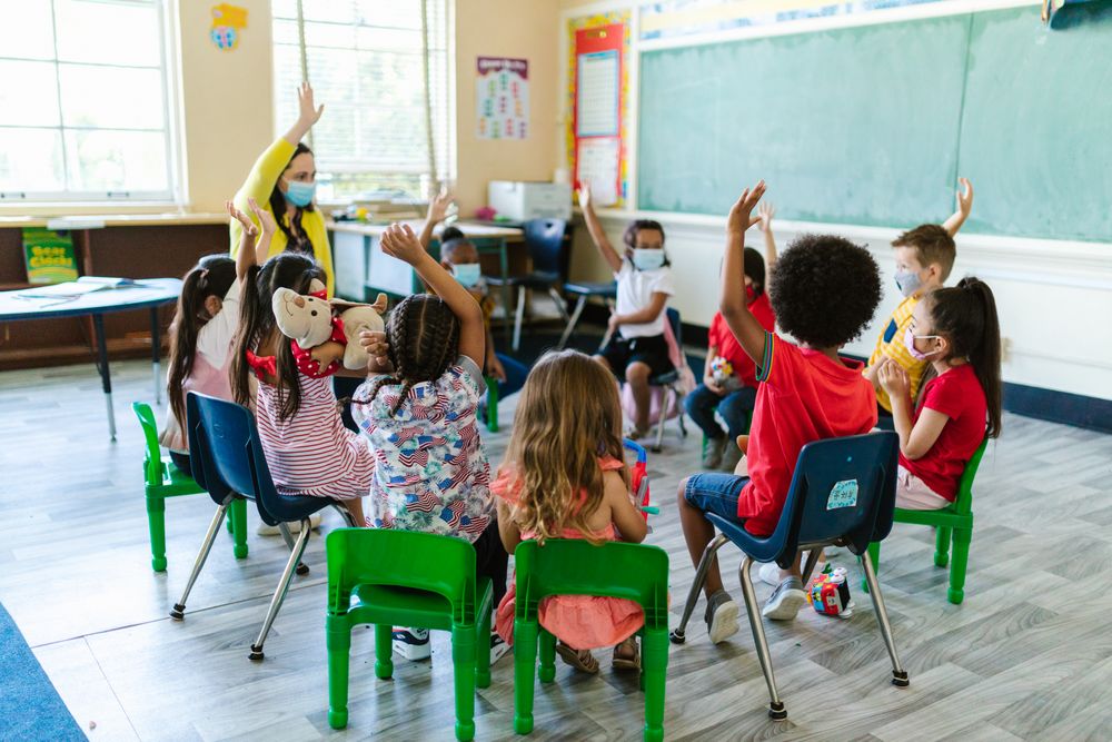 A class of children raising their hands